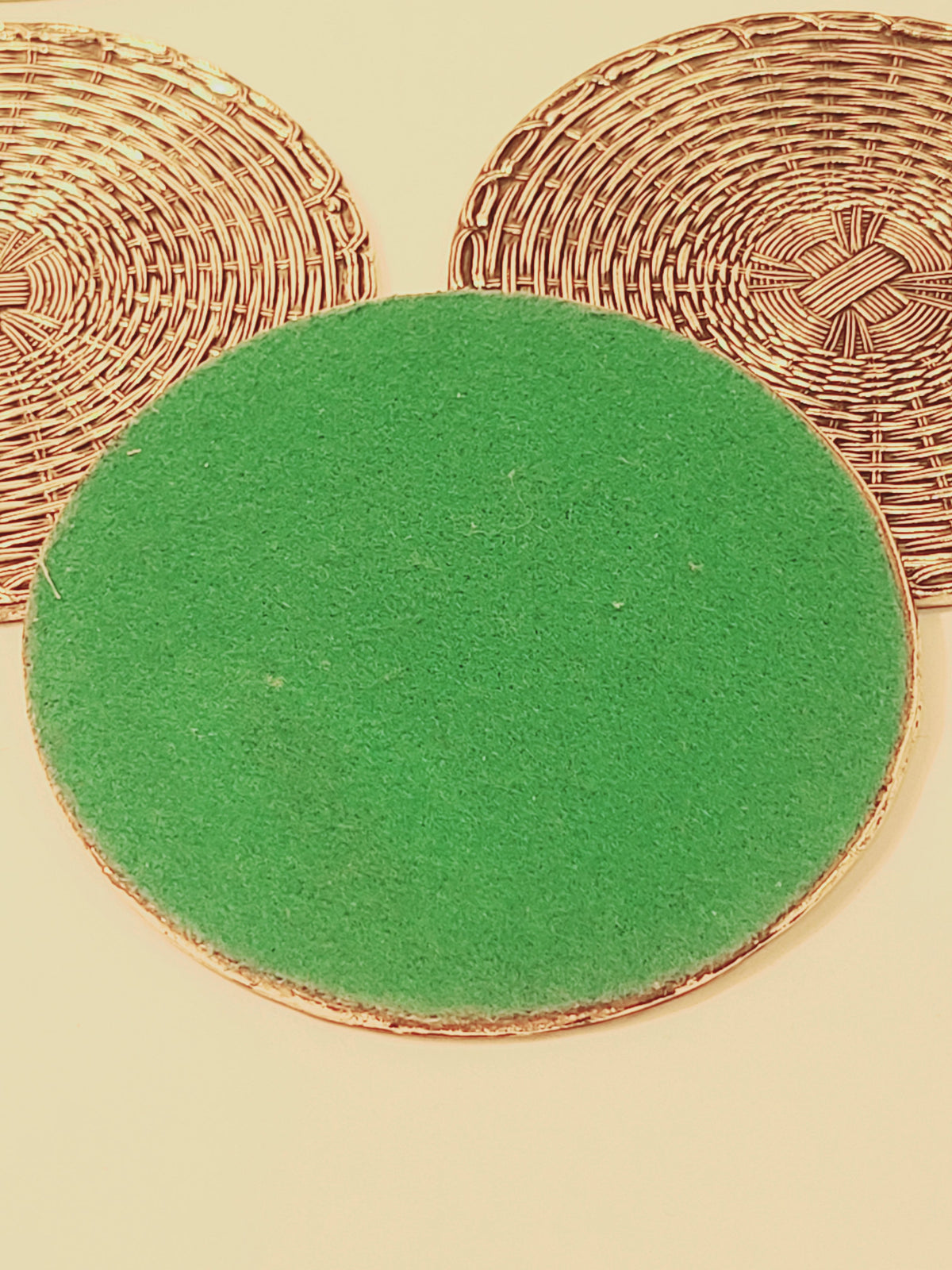 Underside of mid-century woven metal coaster showing green felt backing, vintage European drink coaster set of 5