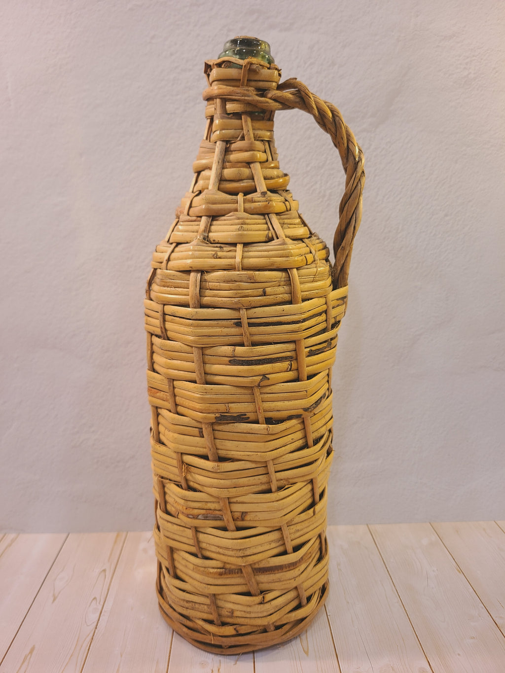Vintage pale green glass demijohn with original woven rattan wrapping and attached handle