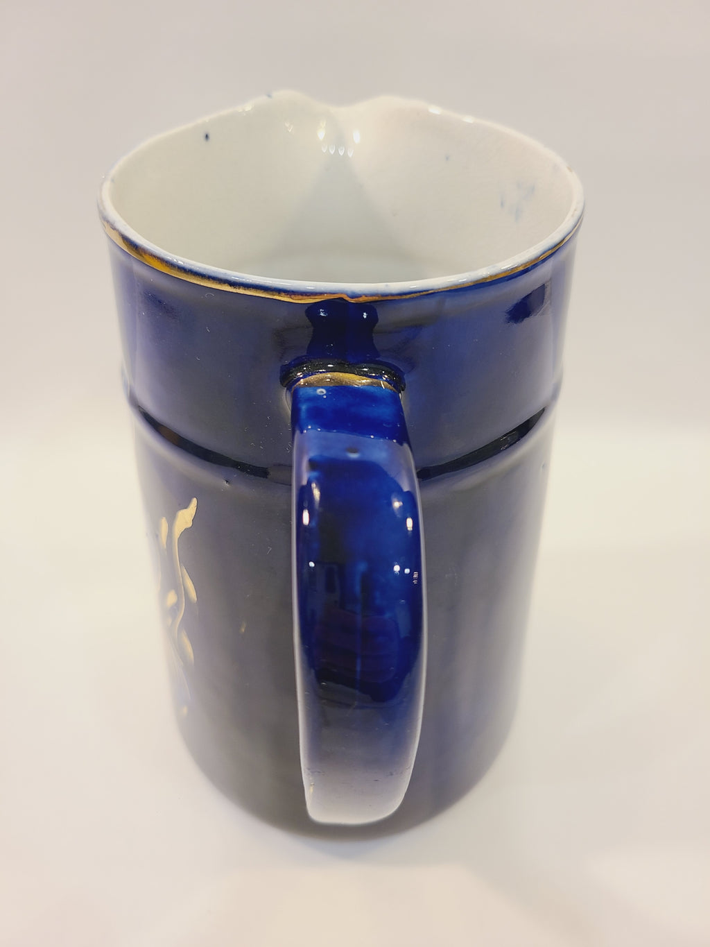 Close-up of the cobalt blue pitcher’s handle and gold-trimmed rim