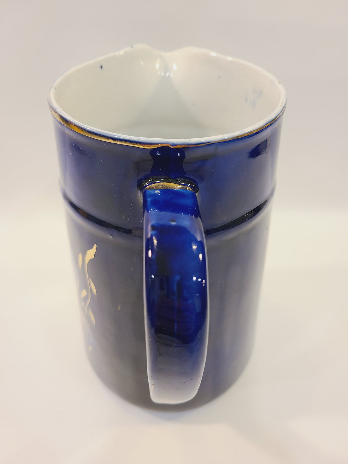 Close-up of the cobalt blue pitcher’s handle and gold-trimmed rim