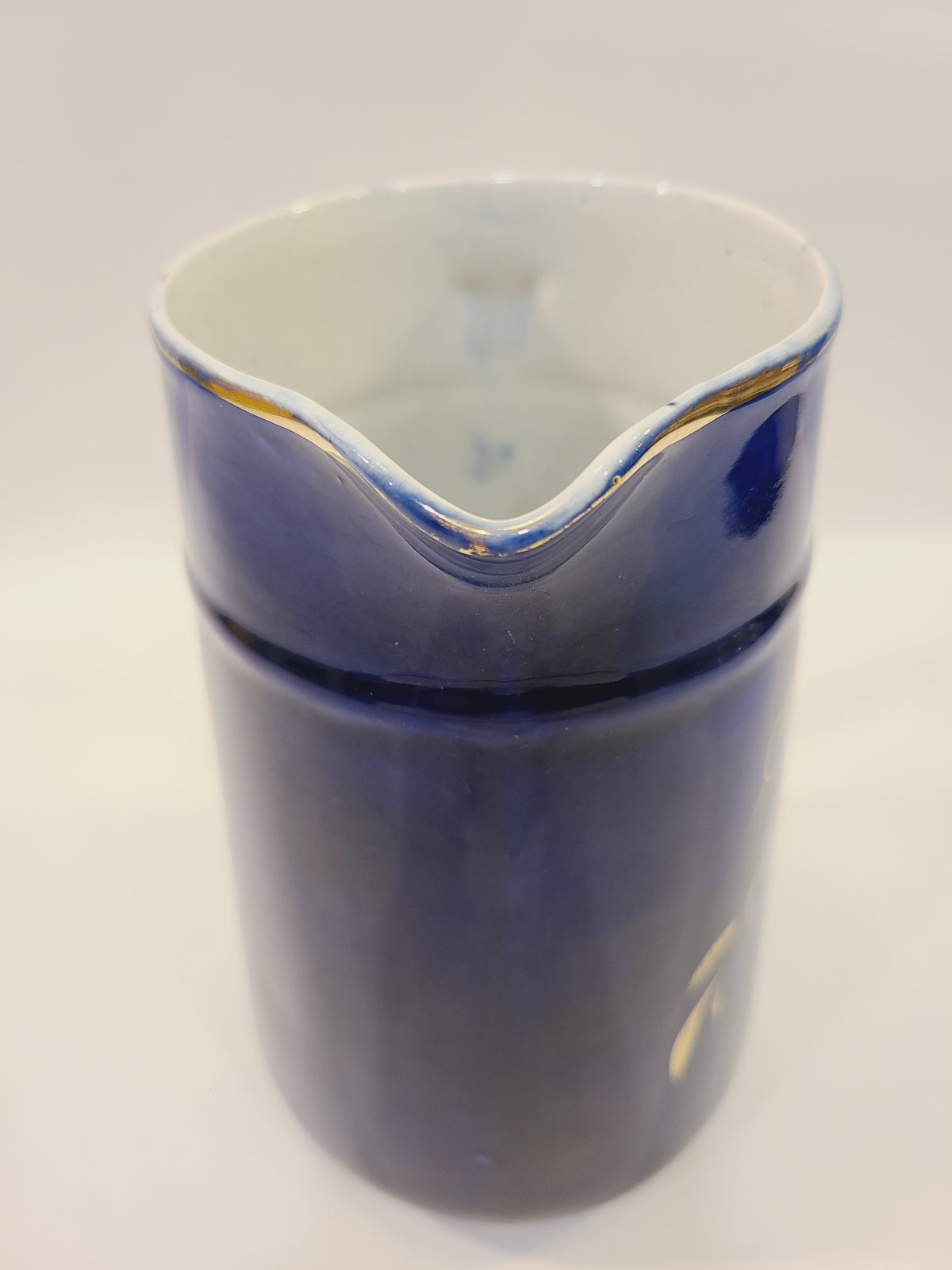 Top view of the pitcher opening showing cobalt blue glaze and gold trim