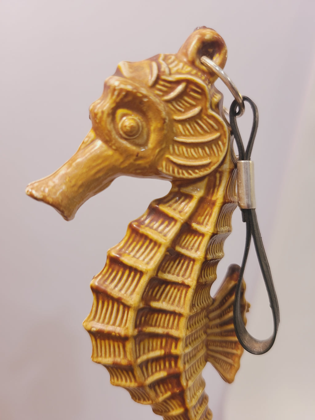 Close-up of the seahorse brush handle showing its detailed face, fin texture, and hanging loop