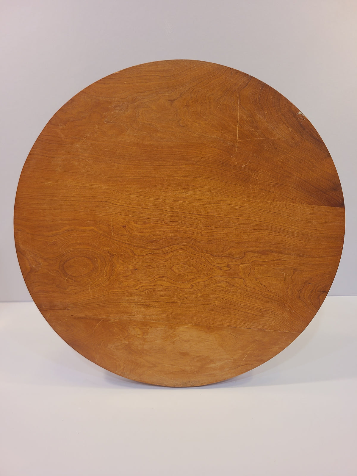 Plain wood underside of a round vintage inlaid serving tray