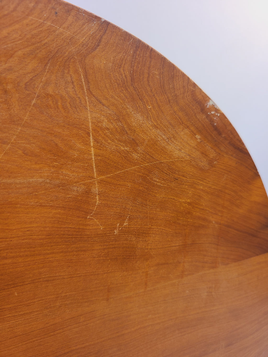 Close-up of superficial surface scratches and natural wood grain on the tray underside