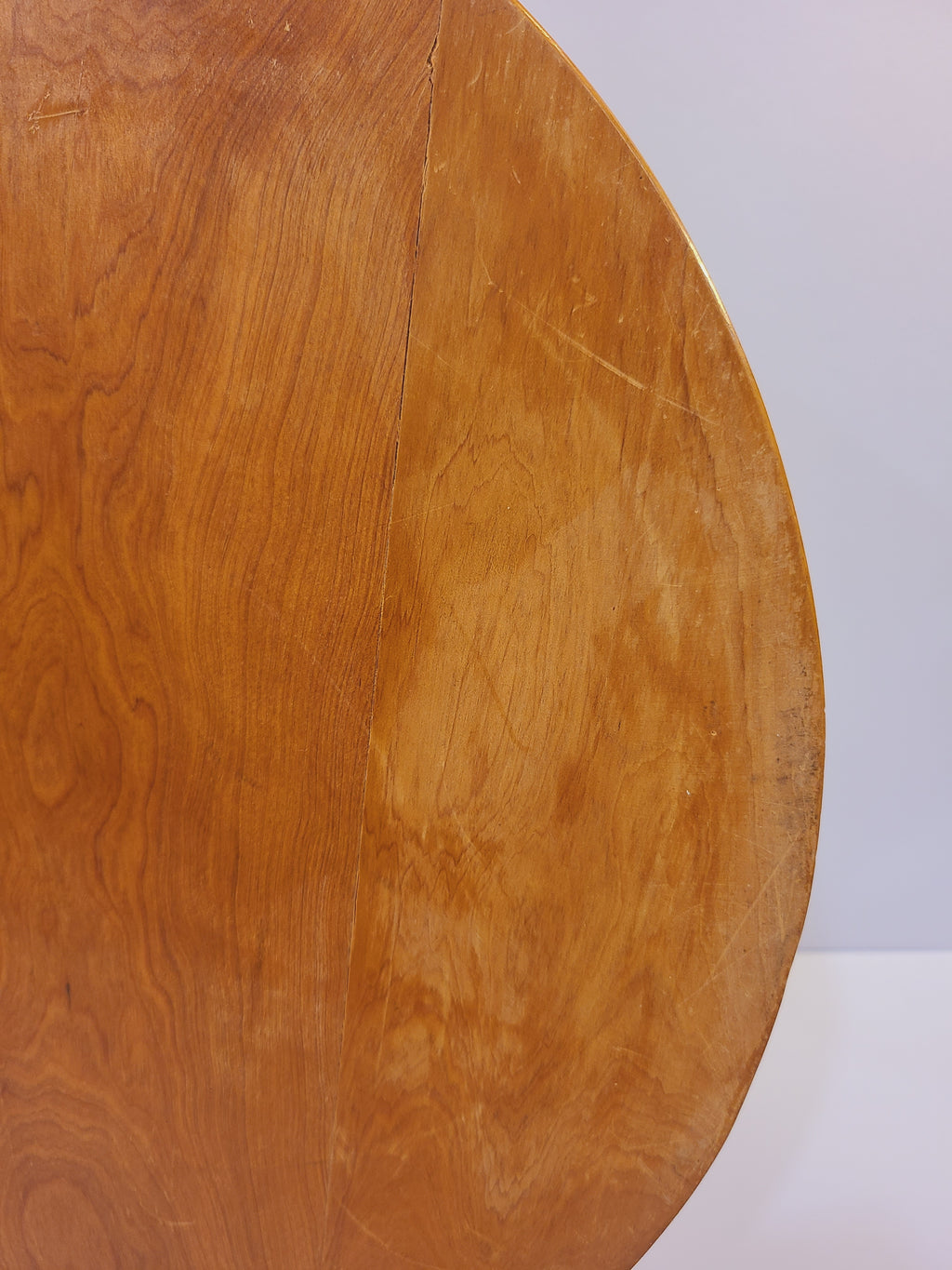 Close-up of the underside of a vintage inlayed wood tray showing natural grain and minor age-related wear