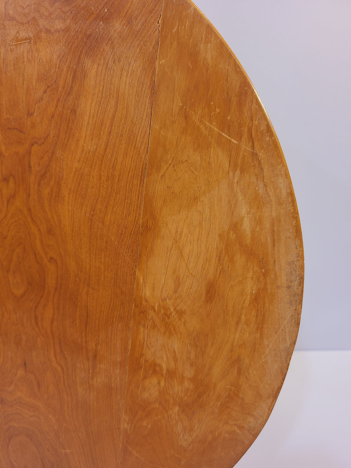 Close-up of the underside of a vintage inlayed wood tray showing natural grain and minor age-related wear