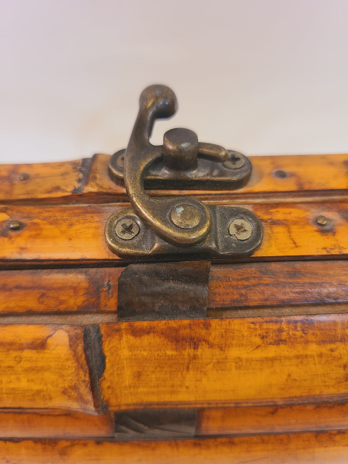 Close-up of the brass-tone swivel latch on a vintage bamboo box handbag