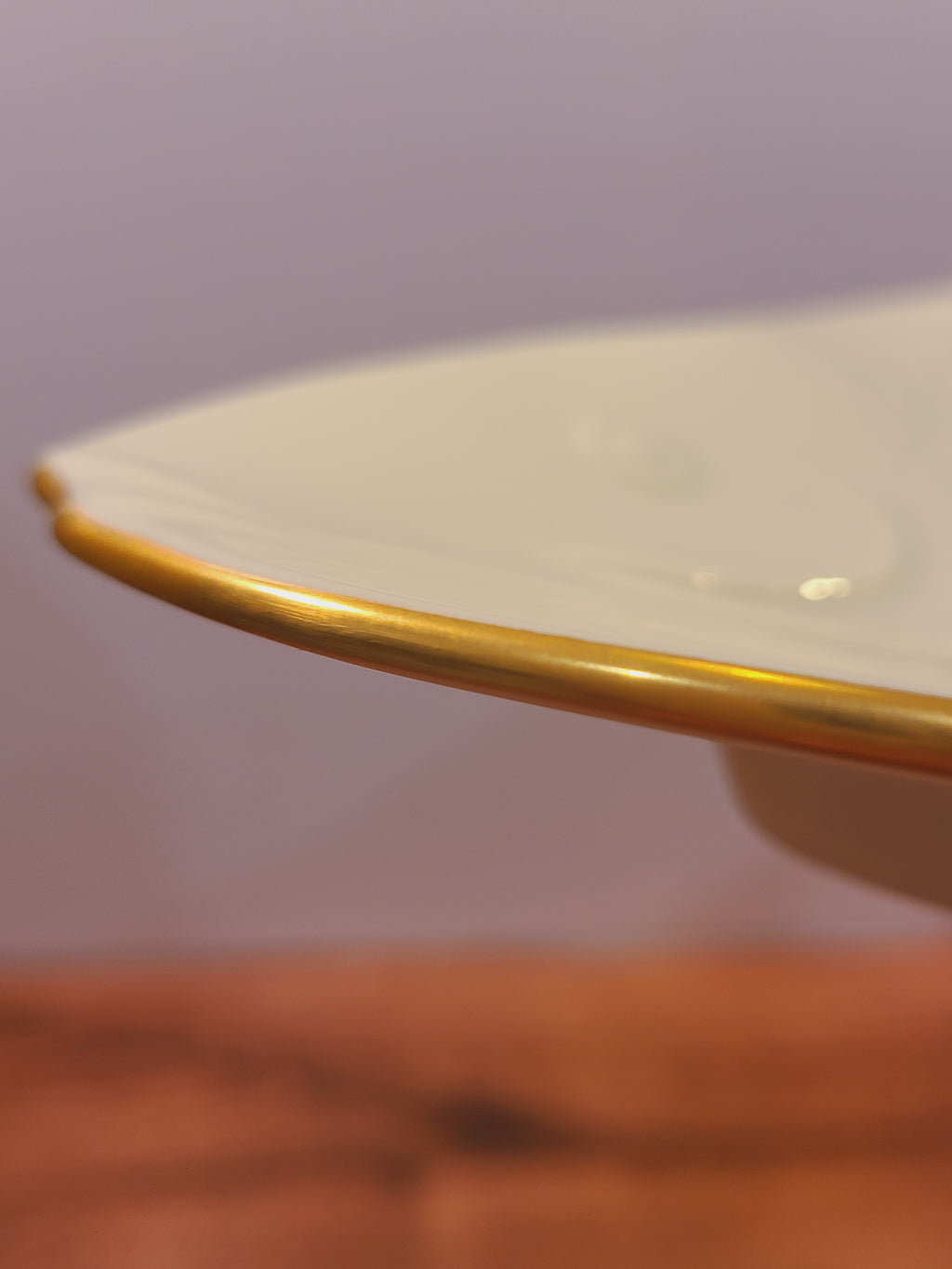 Close-up of the platter’s 24K gold-trimmed edge and glossy ivory bone china