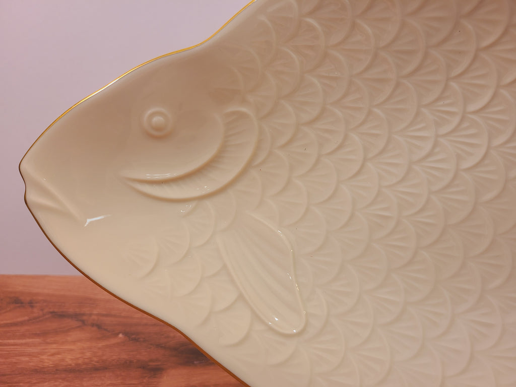 Close-up of embossed fish scales, eye, and fin details on an ivory Lenox Seaport platter