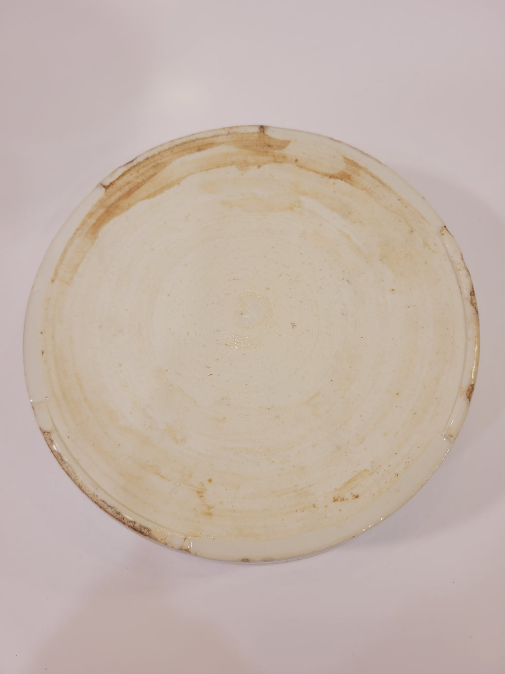 Underside of blue and white porcelain serving bowl showing the unglazed foot ring