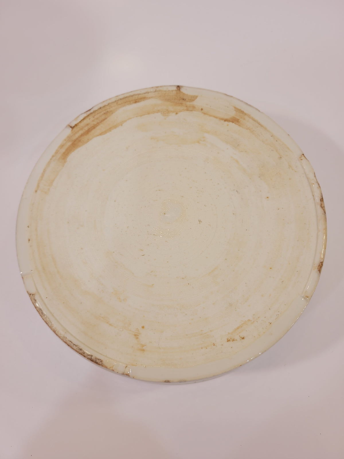 Underside of blue and white porcelain serving bowl showing the unglazed foot ring
