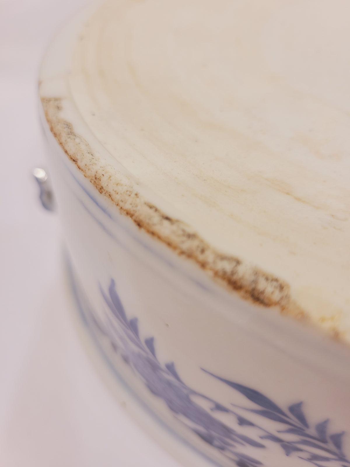 Close-up of chips and age-related wear along the bowl’s unglazed foot ring